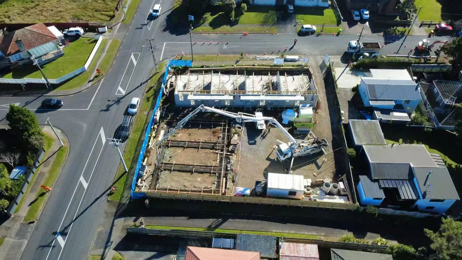 Concrete pump working beside prepared multi-unit foundations
